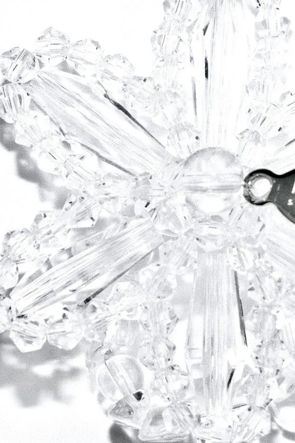Close-up of clear crystal snowflake ornament with intricate faceted beads and silver hook