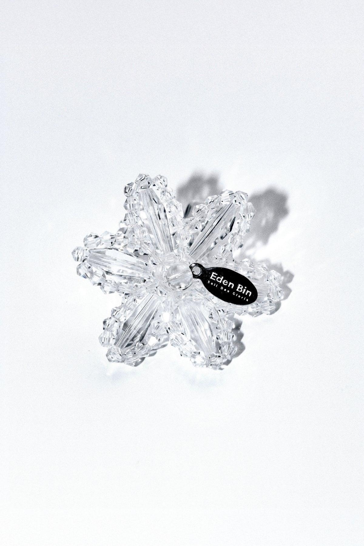 Clear crystal flower-shaped hair clip with Eden Bin brand tag on white background