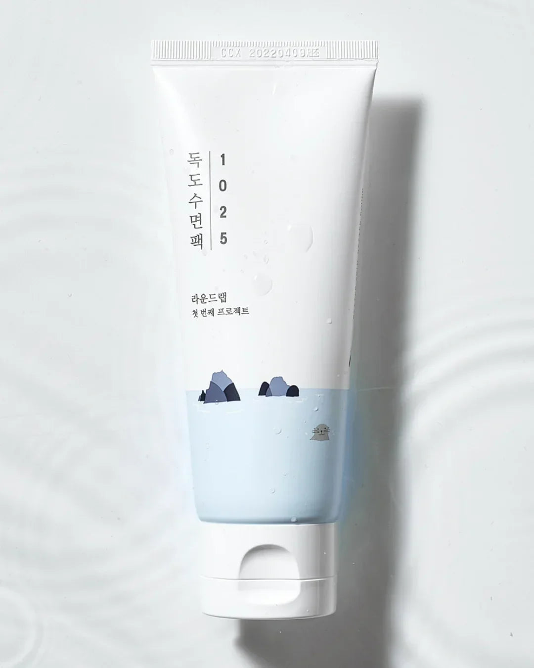 Tube of 1025 Dokdo Sleeping Pack with blue water and rock illustration on white background