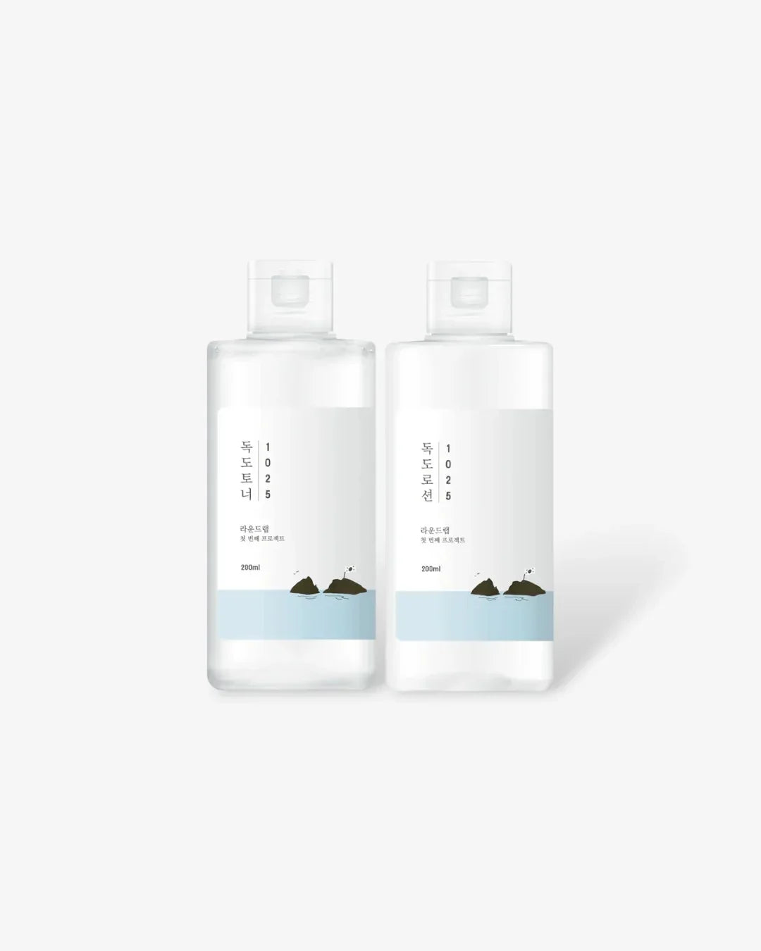 Two clear plastic bottles of Dokdo skincare toner and lotion with minimalist blue and white labels