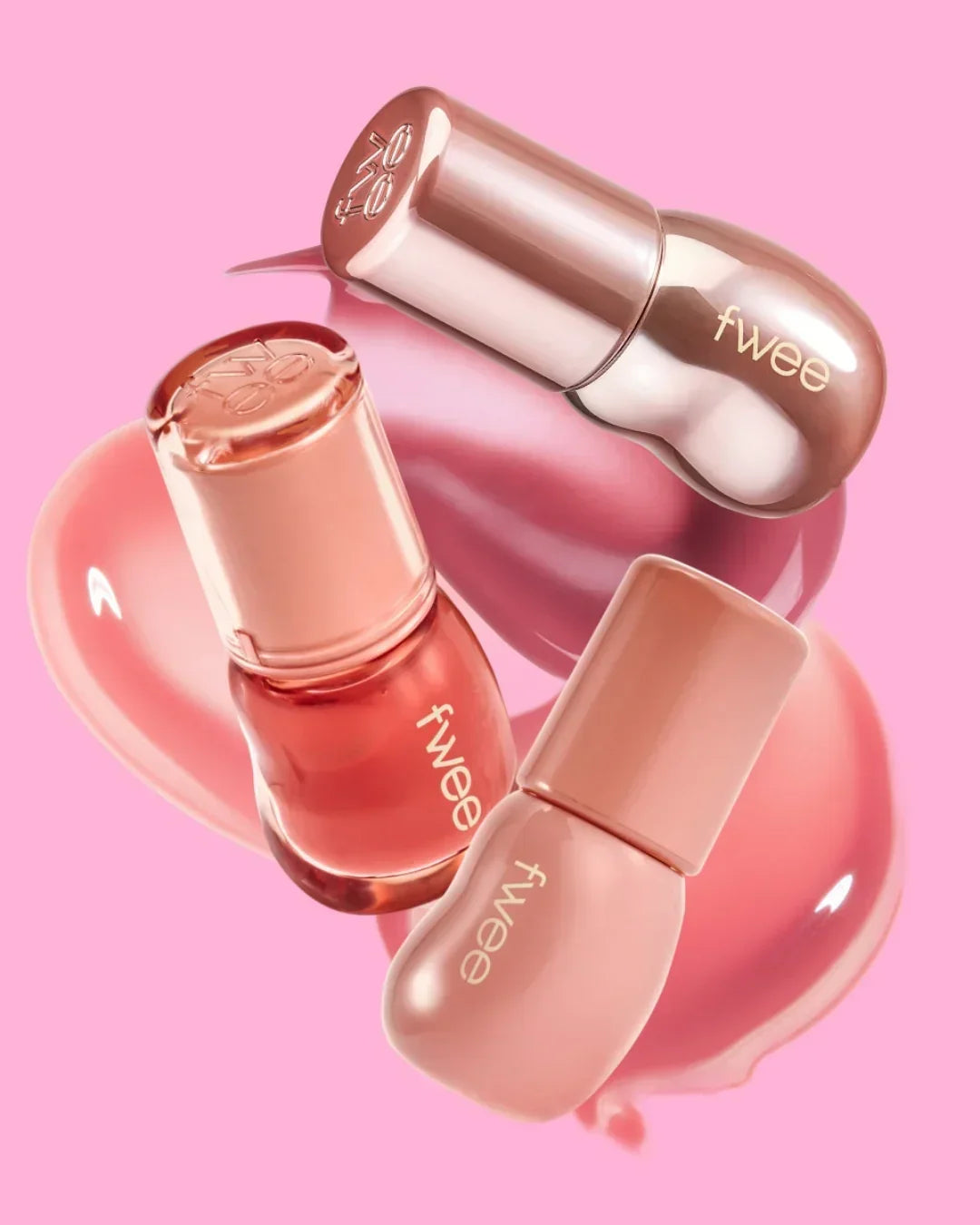 Fwee brand nail polish and lip gloss in pink and nude shades on a pink background