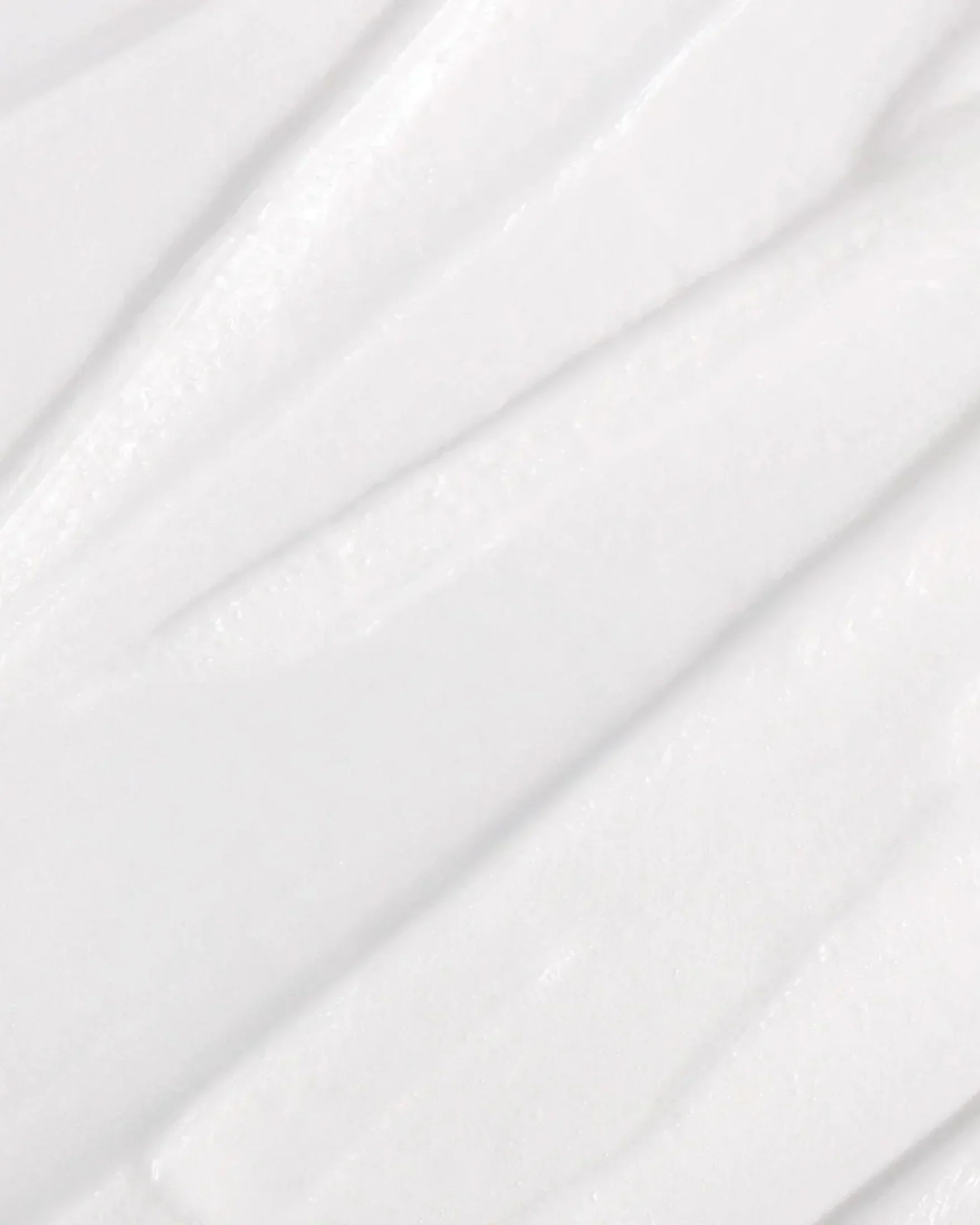 Close-up texture of smooth white cleansing foam with creamy rich consistency