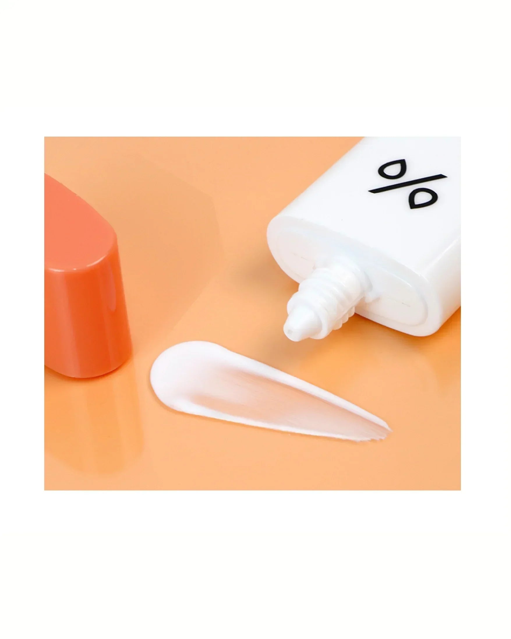 White tube of Control No Sebum Sun Lotion with orange cap and lotion texture swatch on peach background