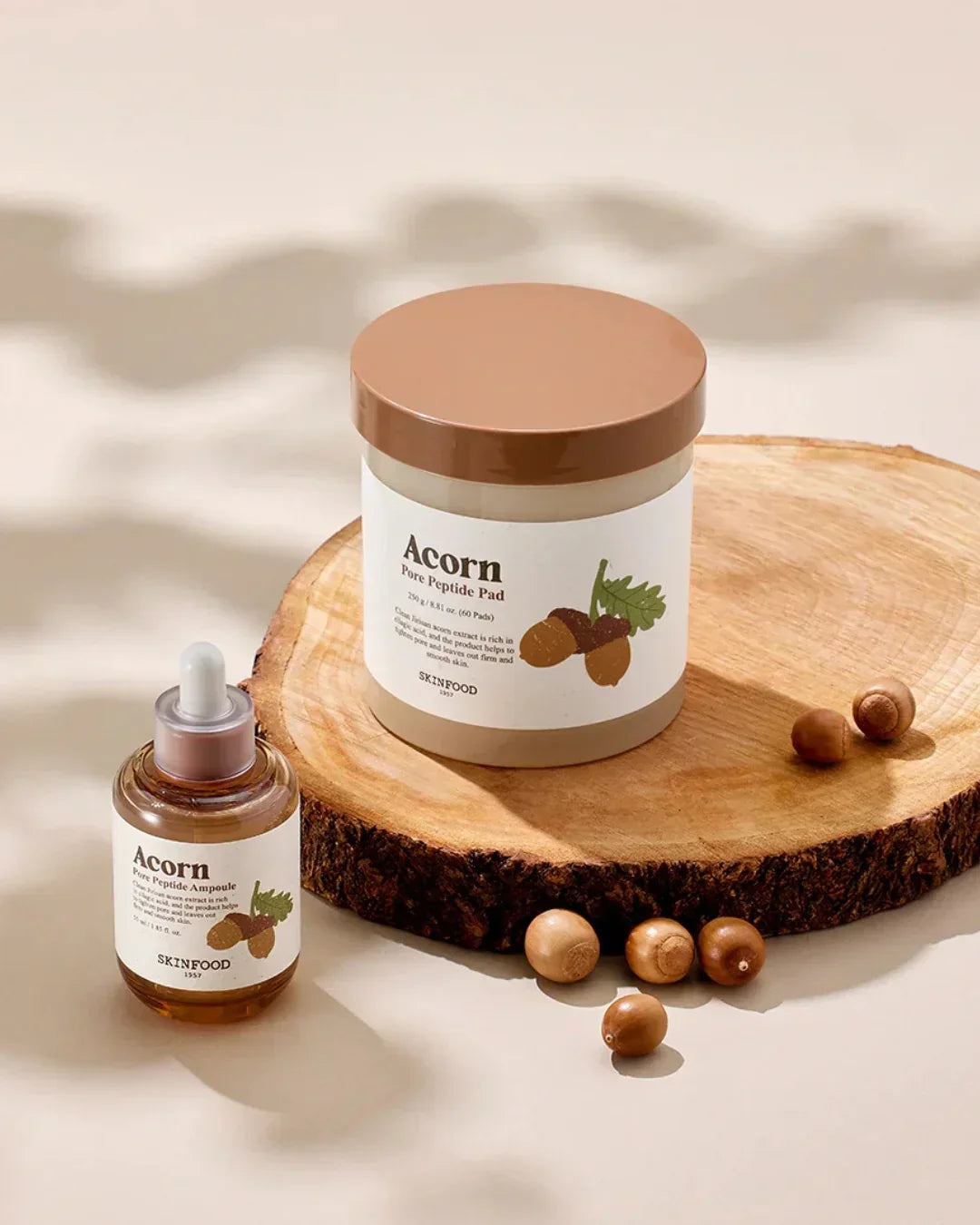 Skinfood Acorn Pore Peptide Pad and Ampoule on wooden slab with acorns for skincare
