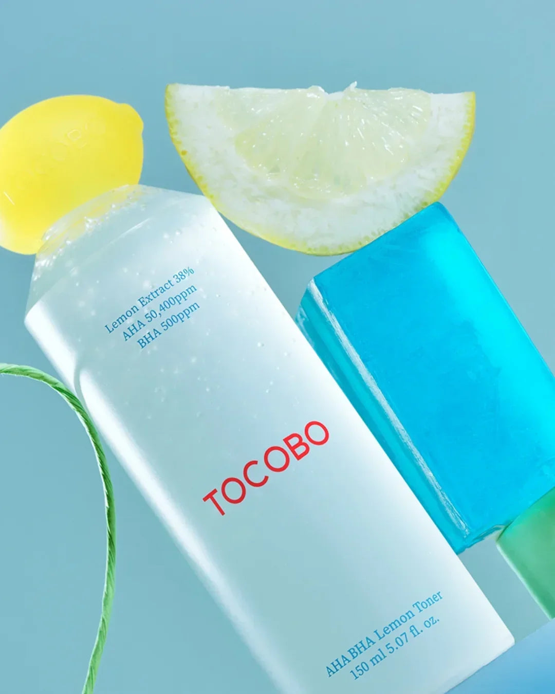 TOCOBO AHA BHA Lemon Toner bottle with lemon slice and blue popsicle on light blue background