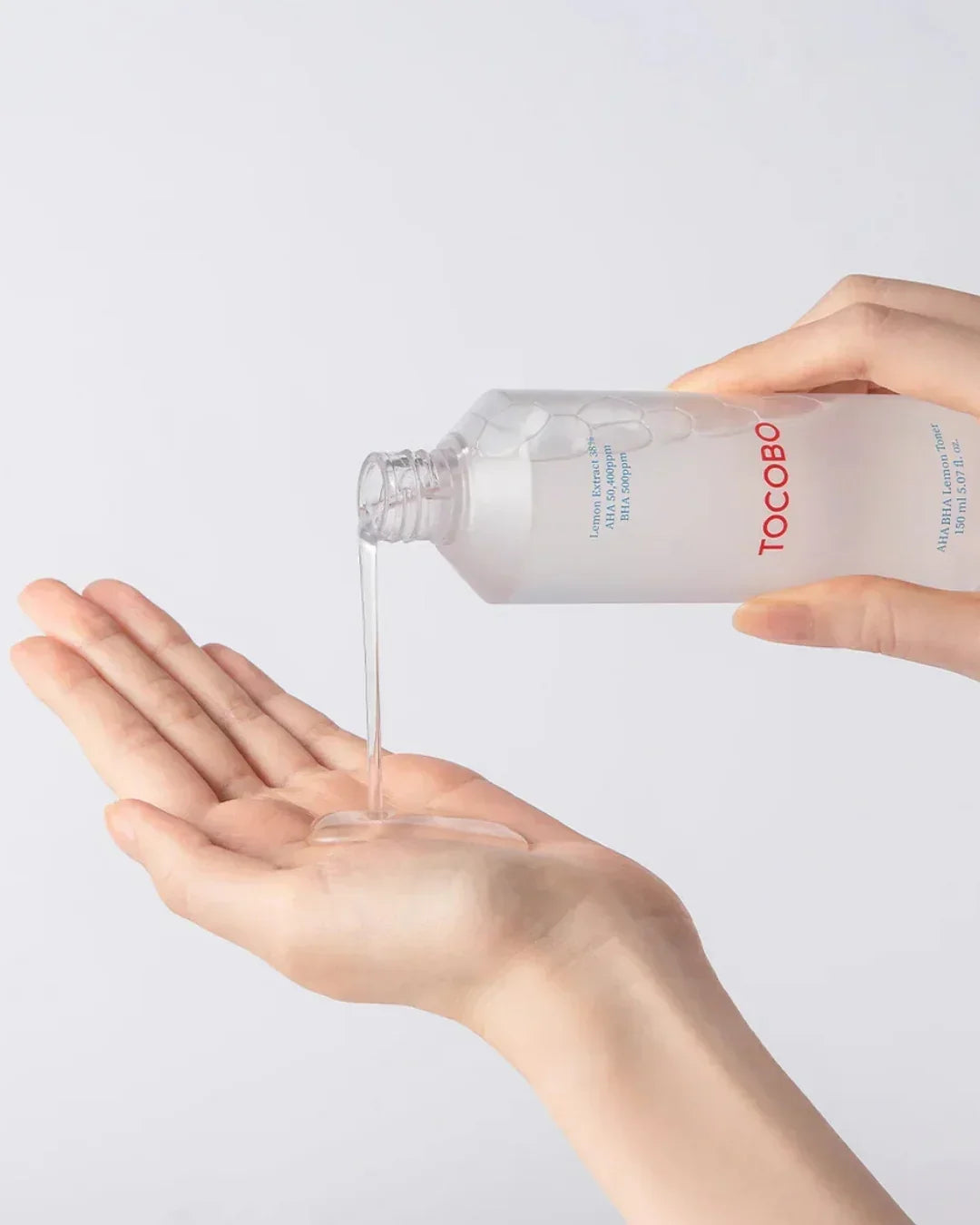 TOCOBO AHA BHA Lemon Toner being poured onto a palm with clear liquid texture