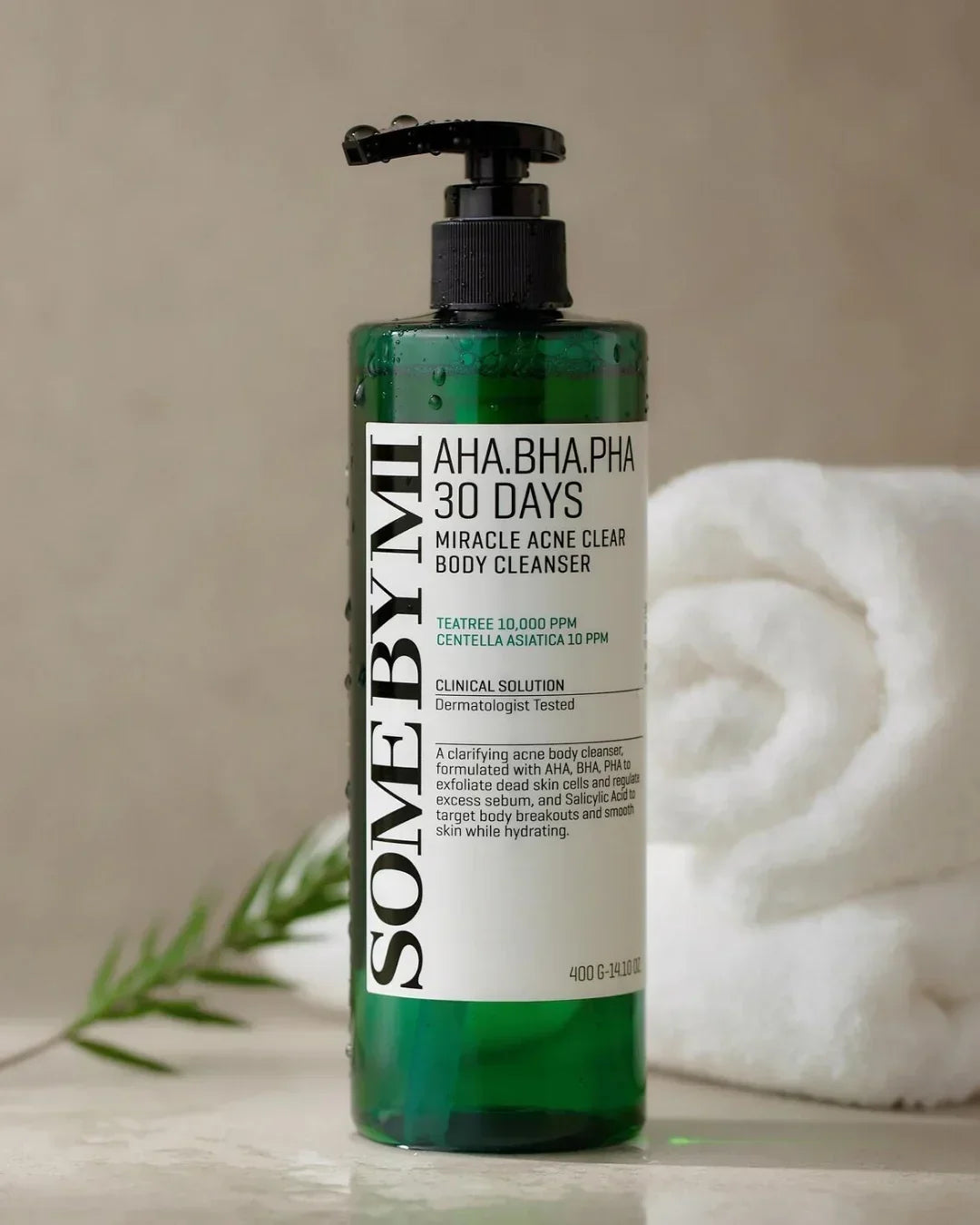 SOME BY MI Miracle Acne Clear Body Cleanser in green bottle with pump, white towel and plant on beige background