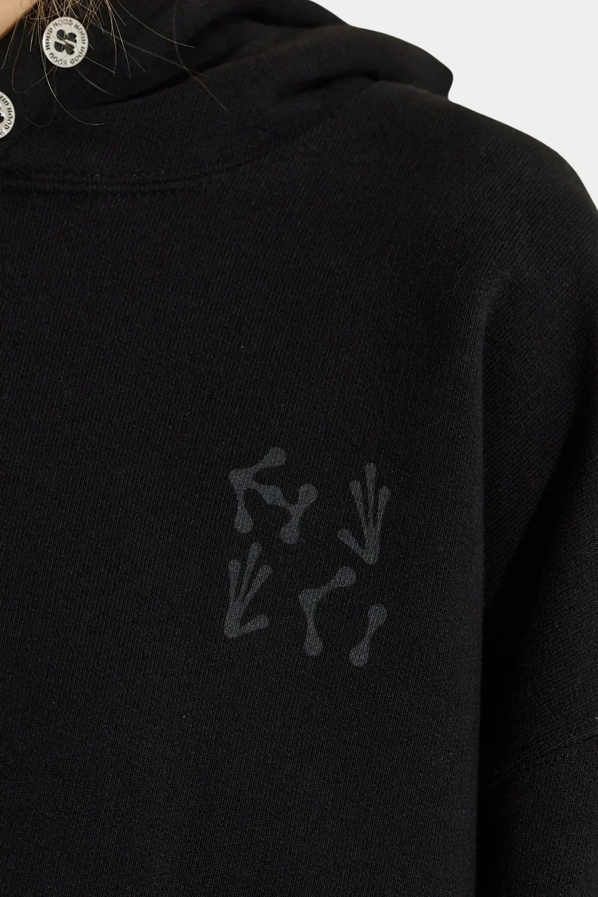 Close-up of black hoodie with subtle alien hands and claw marks graphic print