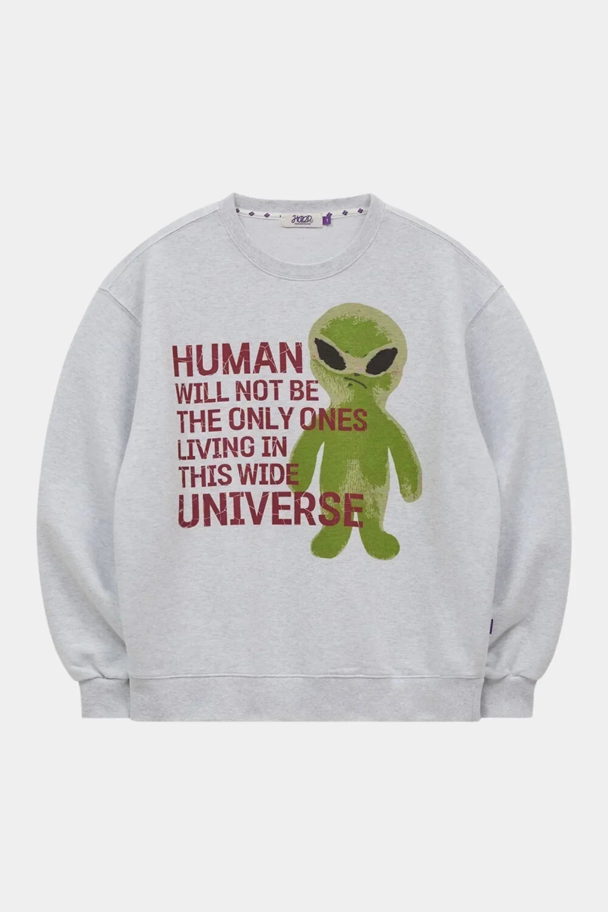 Light grey sweatshirt with green alien graphic and red text saying humans not only living in universe