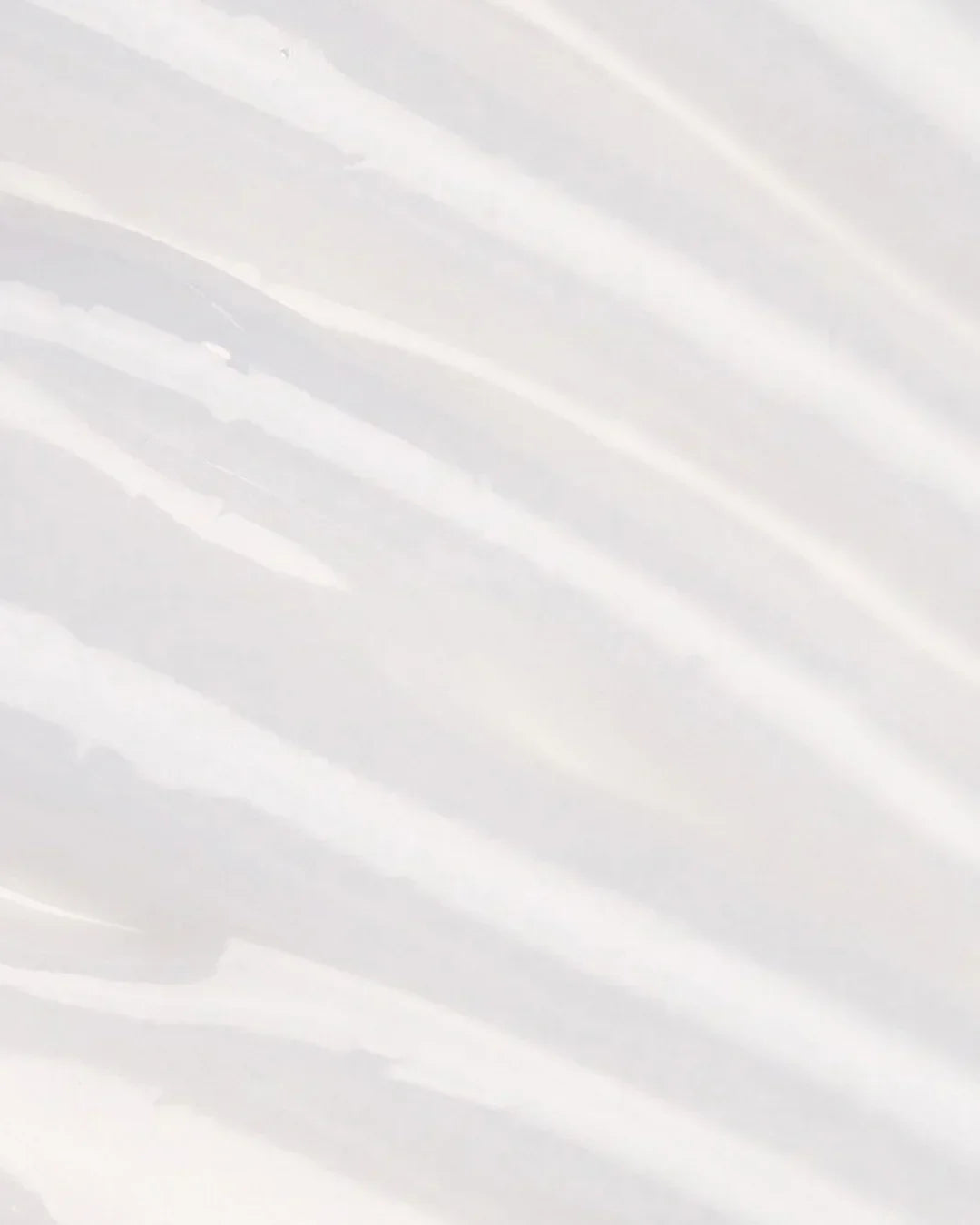 Close-up texture of white aloe soothing emulsion cream spread in smooth streaks