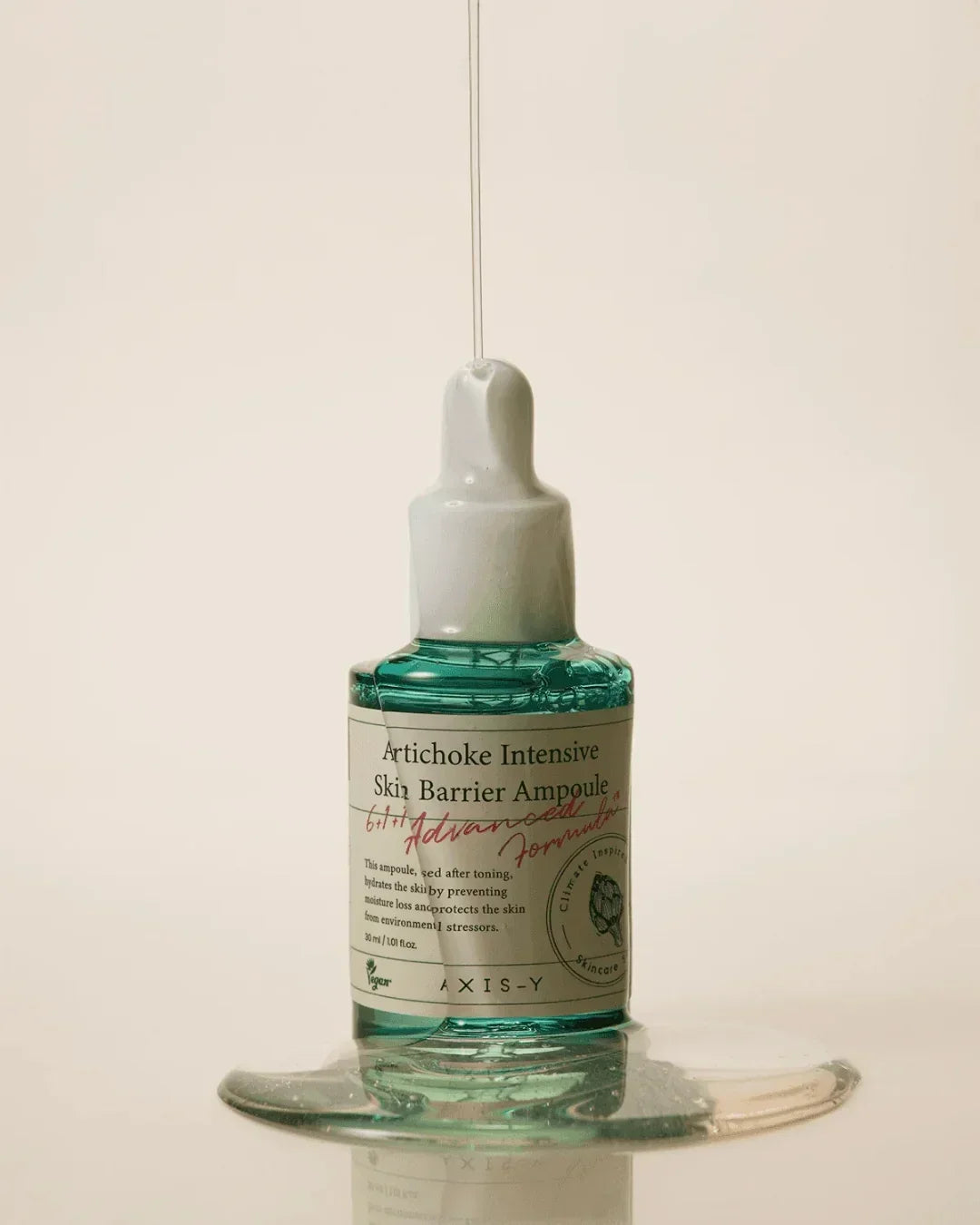 Artichoke Intensive Skin Barrier Ampoule bottle with serum dripping on soft beige background