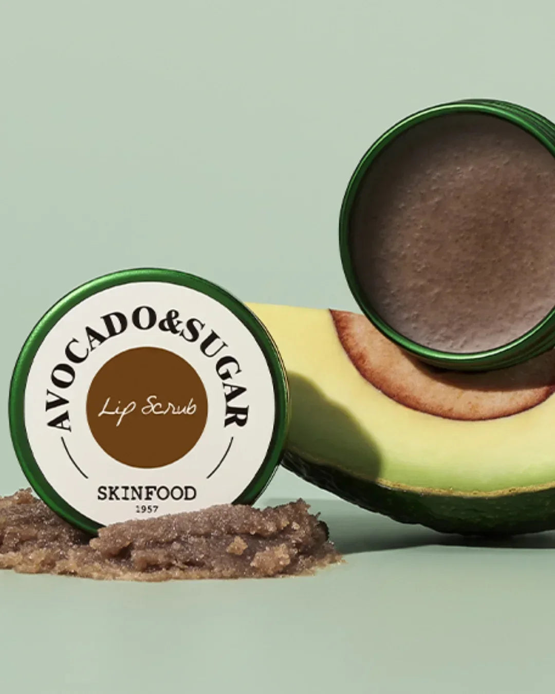 Skinfood Avocado & Sugar Lip Scrub container with opened lid and scrub texture on pastel background
