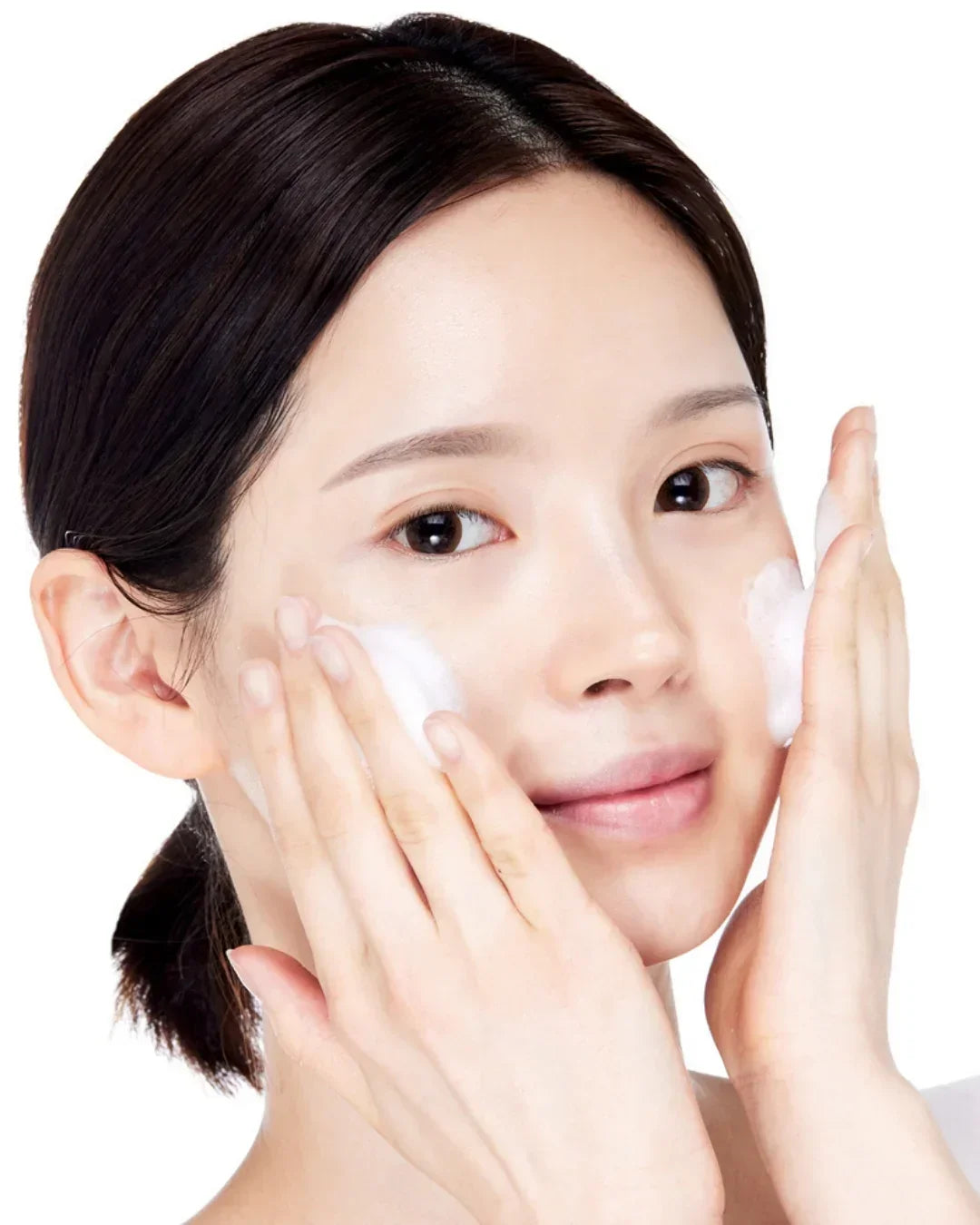 Woman applying foamy baking powder deep cleansing facial foam on clean skin