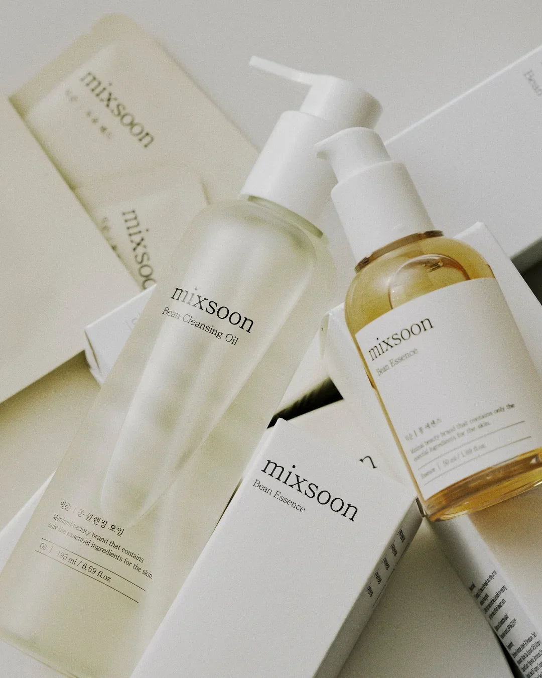 Mixsoon Bean Cleansing Oil and Bean Essence skincare bottles with white pumps and packaging
