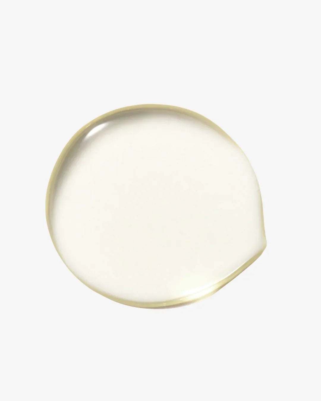 Clear golden cleansing oil drop on white background showing smooth, oily texture