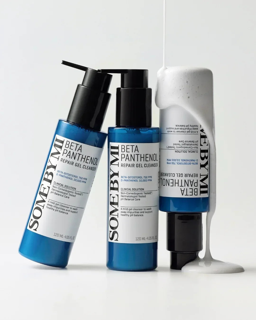 Three blue bottles of SOME BY MI Beta Panthenol Repair Gel Cleanser with white gel dripping on one bottle, studio background