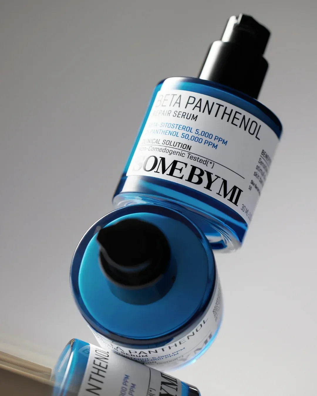 blue bottles of Some By Mi Beta Panthenol Repair Serum with pump dispenser on light background