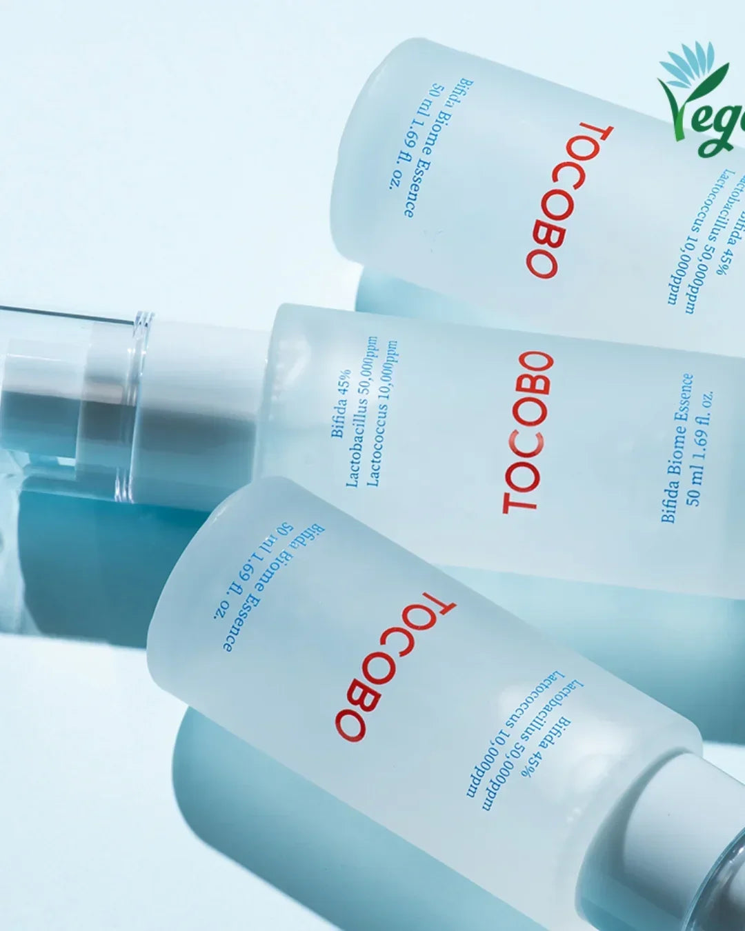 Three frosted glass bottles of TOCOBO Bifida Biome Essence 50ml on a light blue background