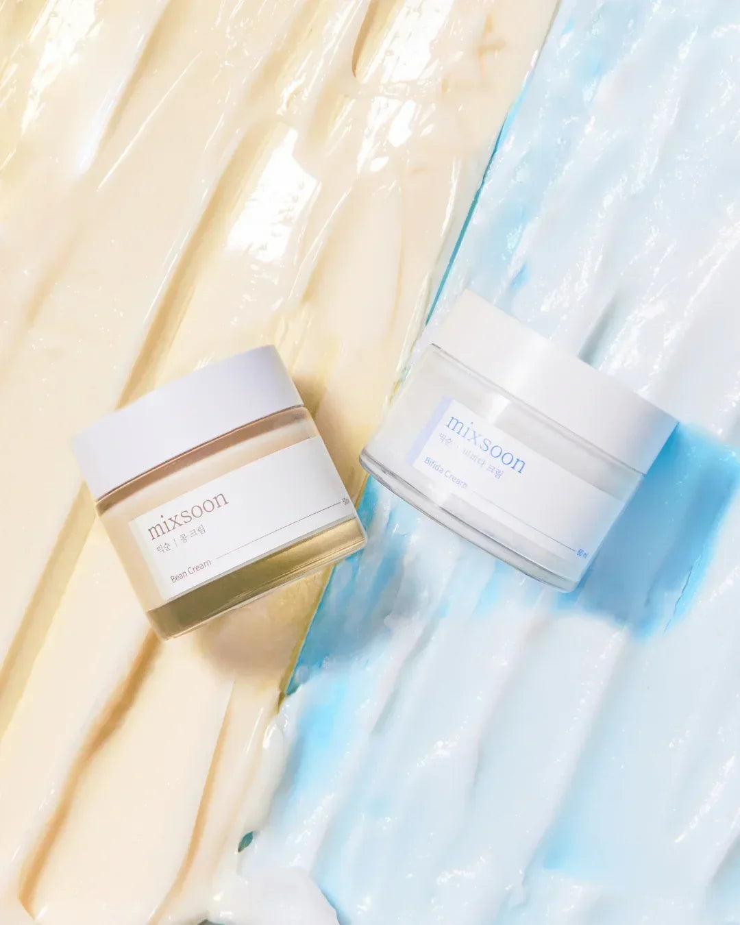 Mixsoon Bean Cream and Bifida Cream jars on textured beige and blue cream backgrounds