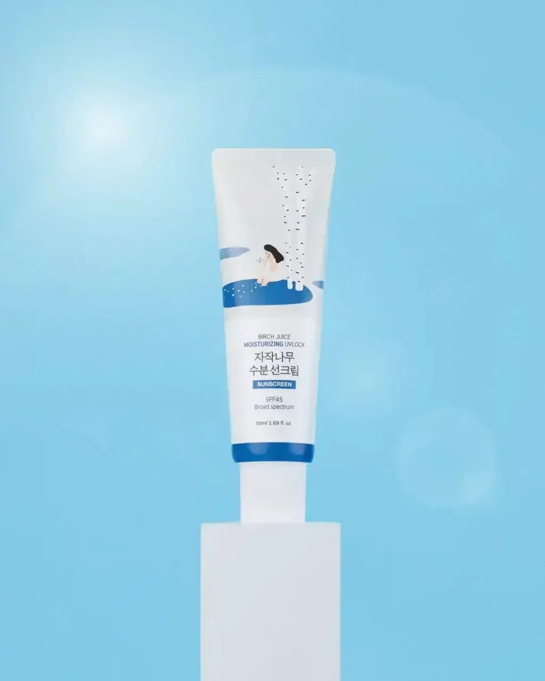 Birch Juice Moisturizing UV Lock sunscreen SPF 45 tube on white stand with blue background