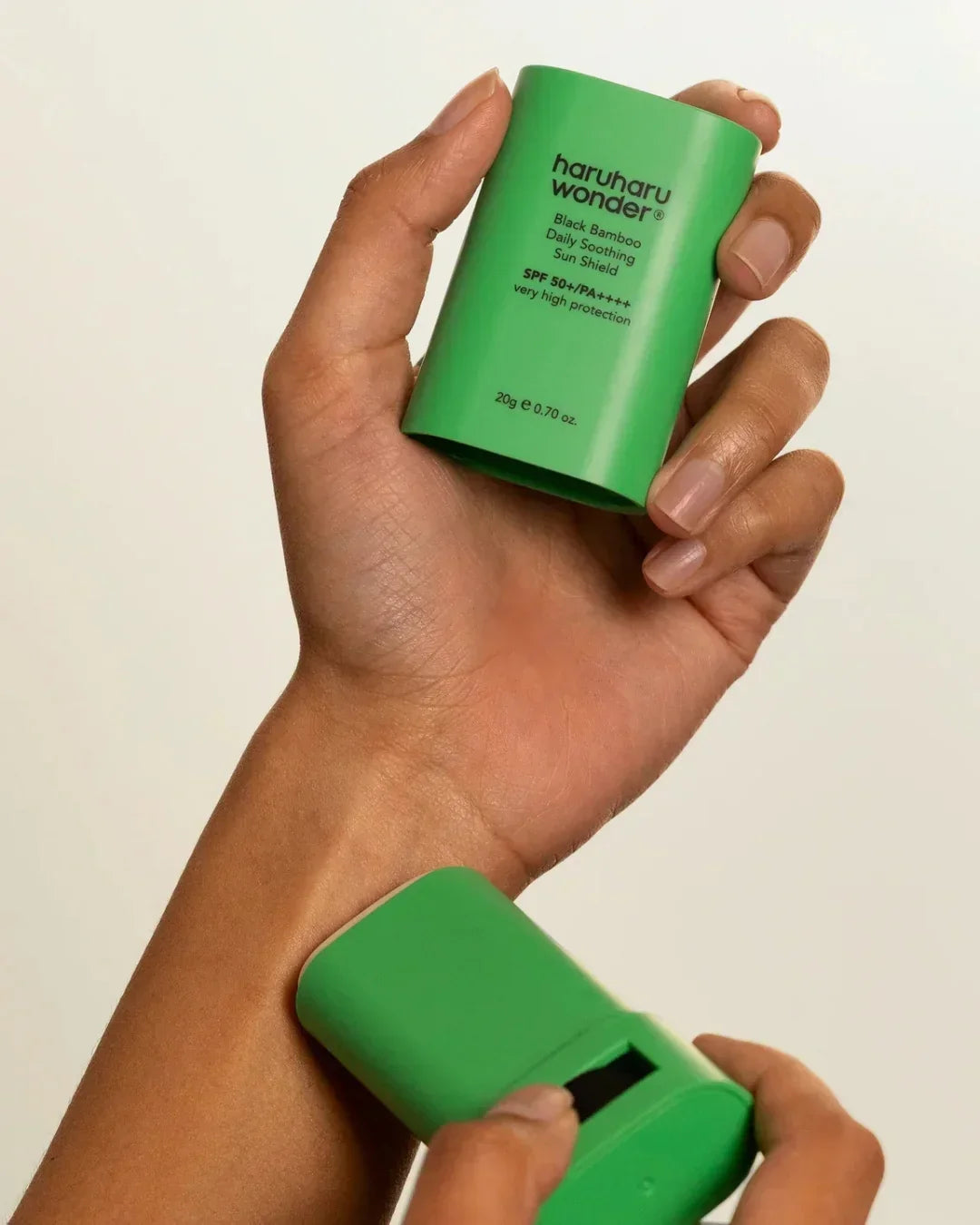 Hand applying Haruharu Wonder Black Bamboo Daily Soothing Sun Shield SPF 50+ PA++++ sunscreen stick