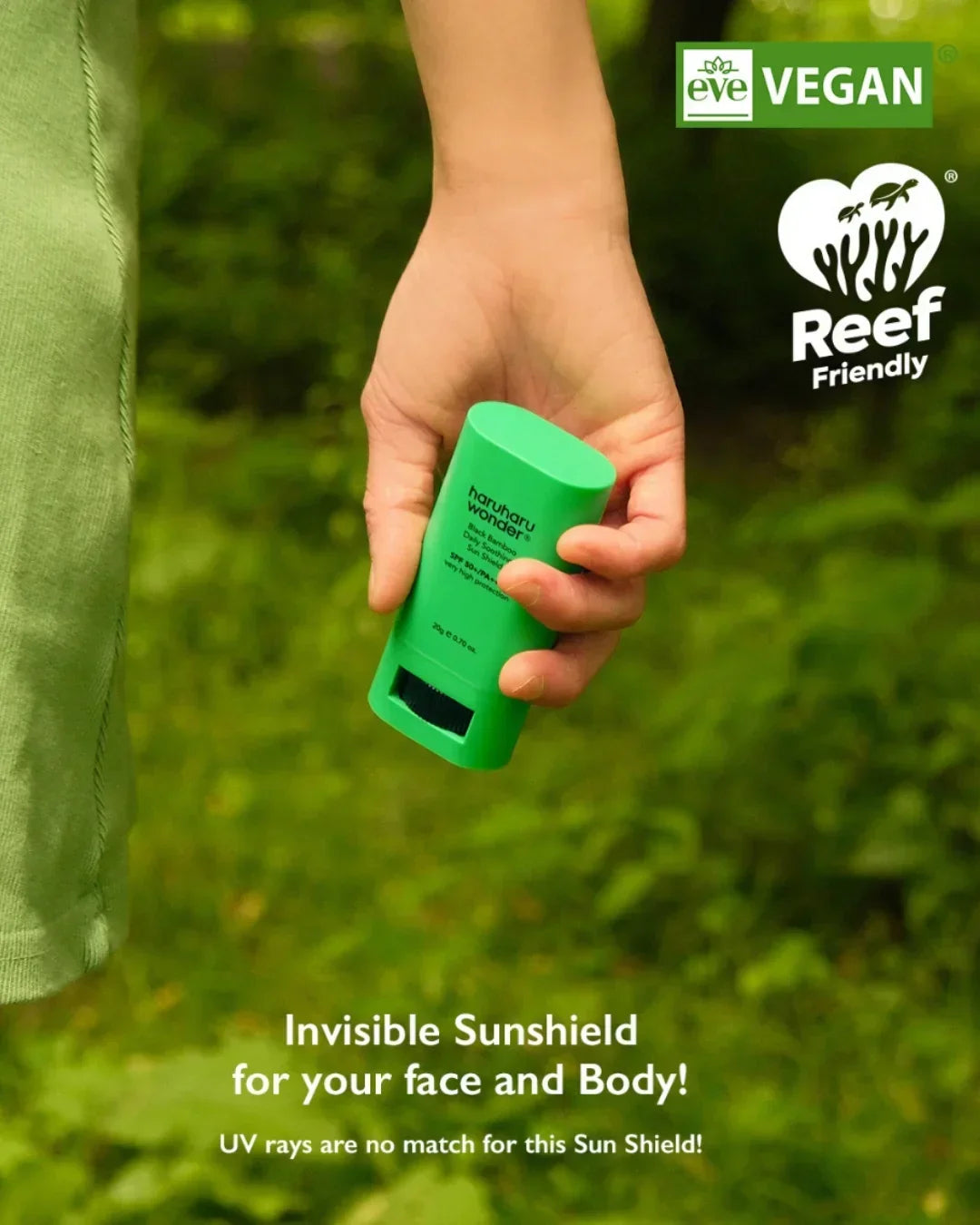 Hand holding green Haruharu Wonder Black Bamboo Daily Soothing Sun Shield sunscreen in nature