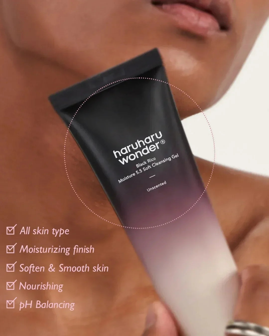 Close-up of a person holding Haruharu Wonder Black Rice Moisture 5.5 Soft Cleansing Gel tube, highlighting benefits for all skin types