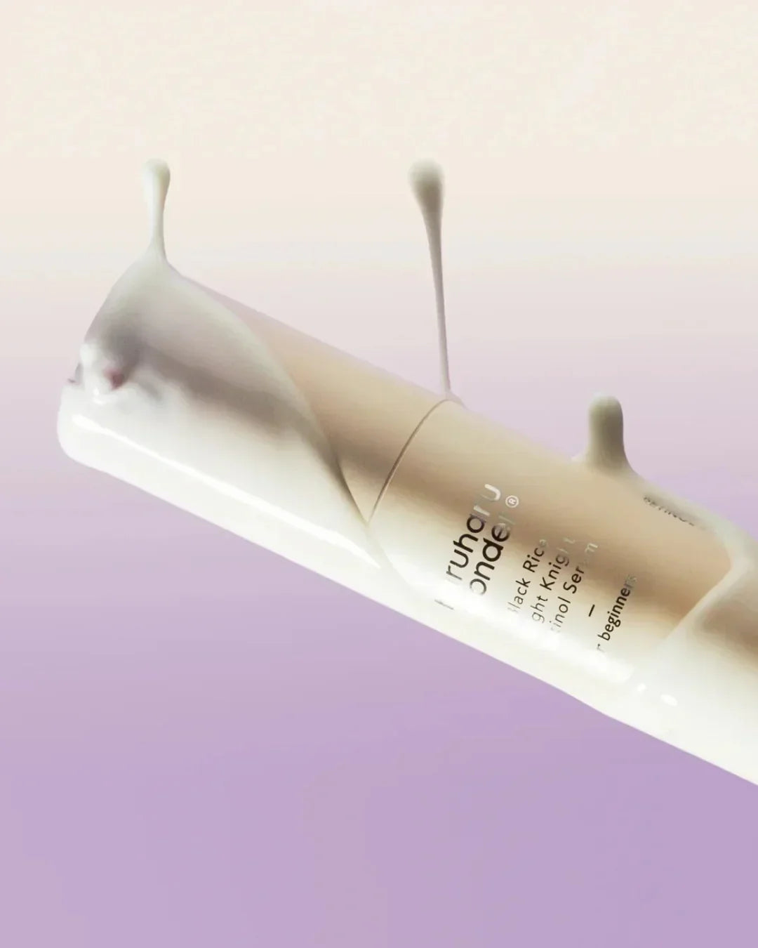 Glow enhancing Black Rice Night Knight Retinol Serum bottle with cream splashes on purple gradient background