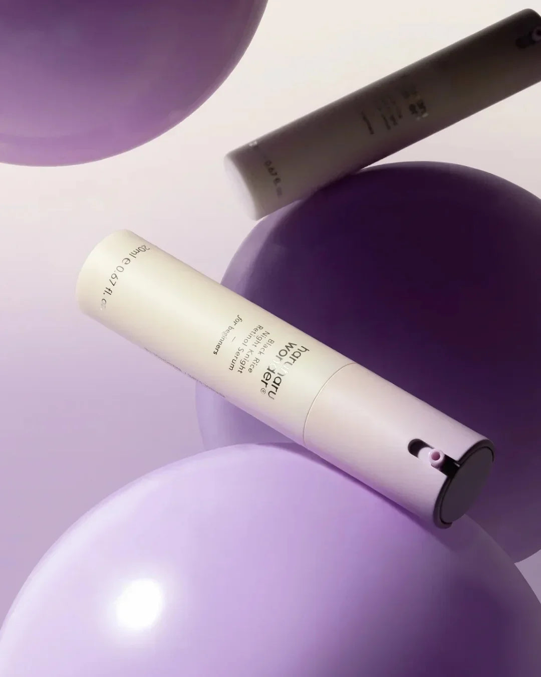 Hourglass Woman black rice night retinol serum 20ml bottle on purple balloons