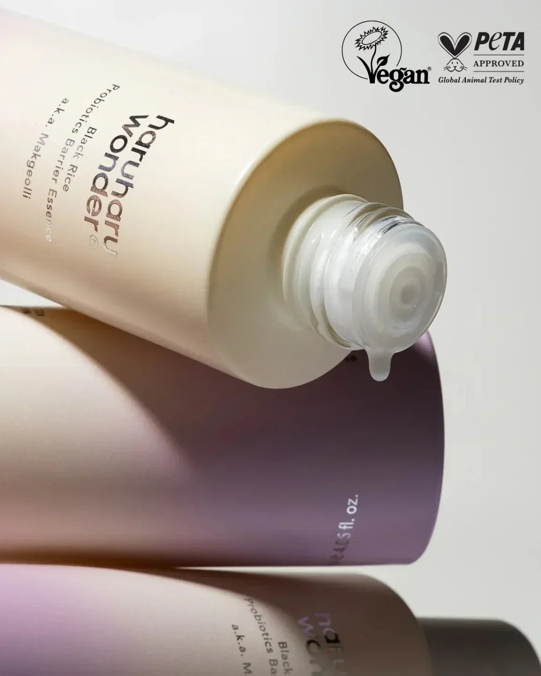 Open bottle of Haruharu Wonder Black Rice Probiotics Barrier Essence with a liquid drop, vegan and PETA approved