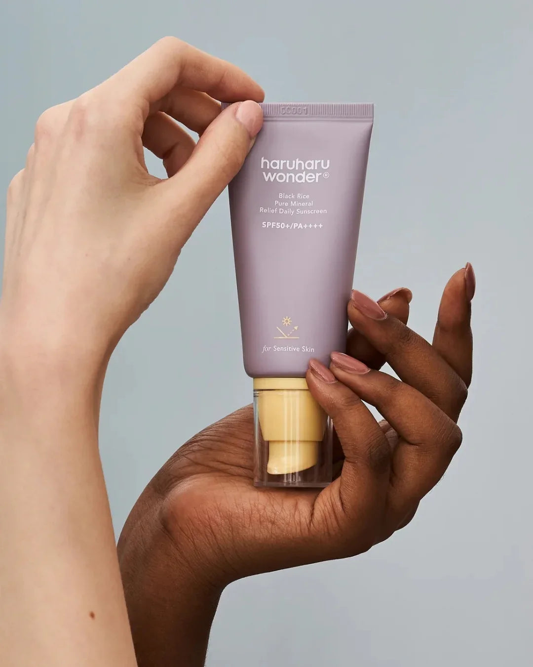 Haruharu Wonder Black Rice Pure Mineral Relief Daily Sunscreen SPF50 held by hands, Korean beauty skincare product