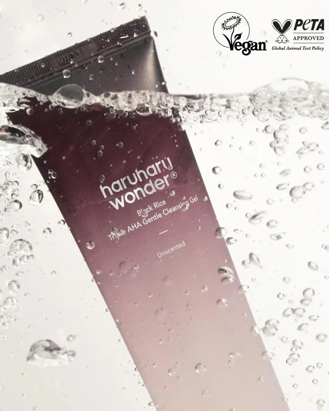 Haruharu Wonder Black Rice Triple AHA Gentle Cleansing Gel tube submerged in water with vegan and PETA logos