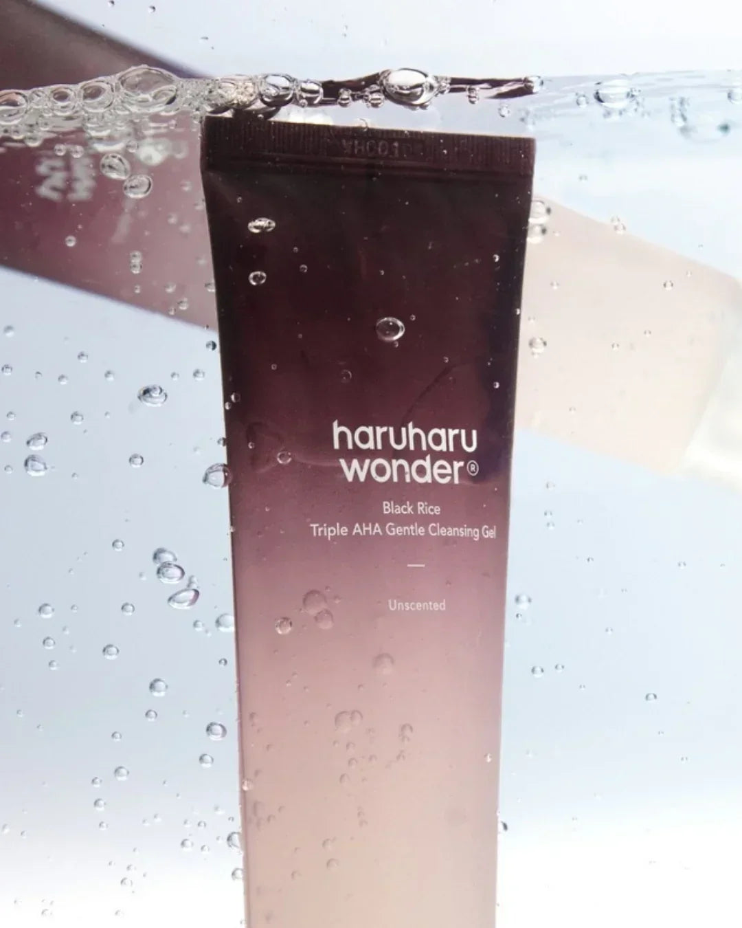 Haruharu Wonder Black Rice Triple AHA Gentle Cleansing Gel tube submerged in water with bubbles