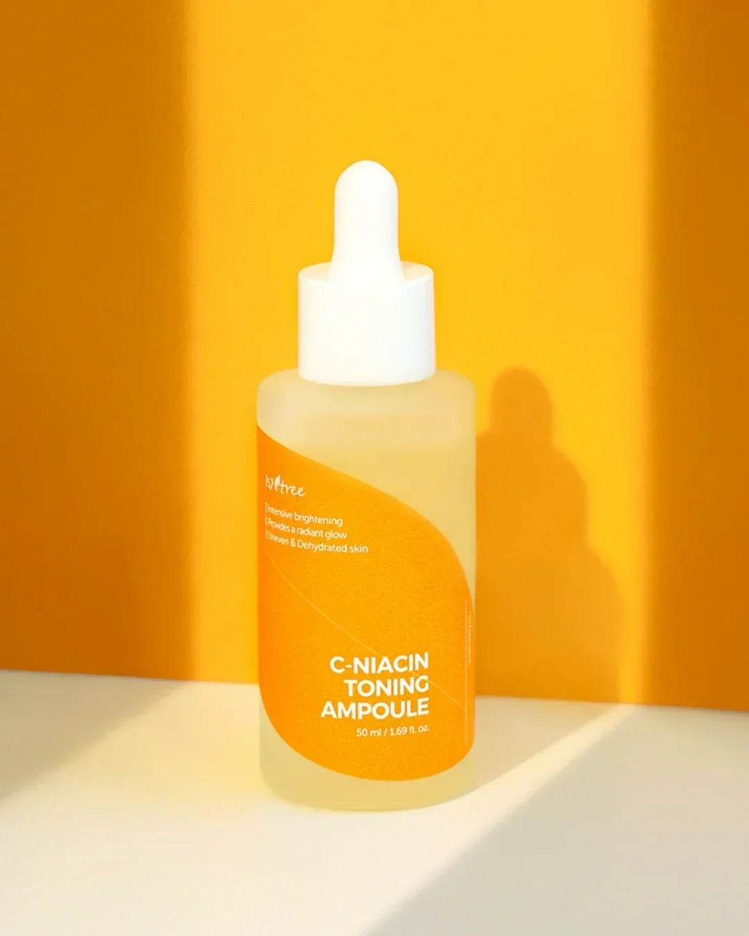 C-Niacin Toning Ampoule bottle with white dropper on yellow and white background