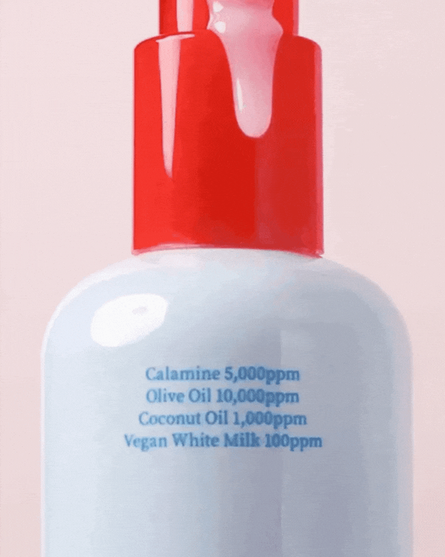Cleansing oil bottle with red pump, highlighting calamine, olive oil, coconut oil, and vegan milk ingredients