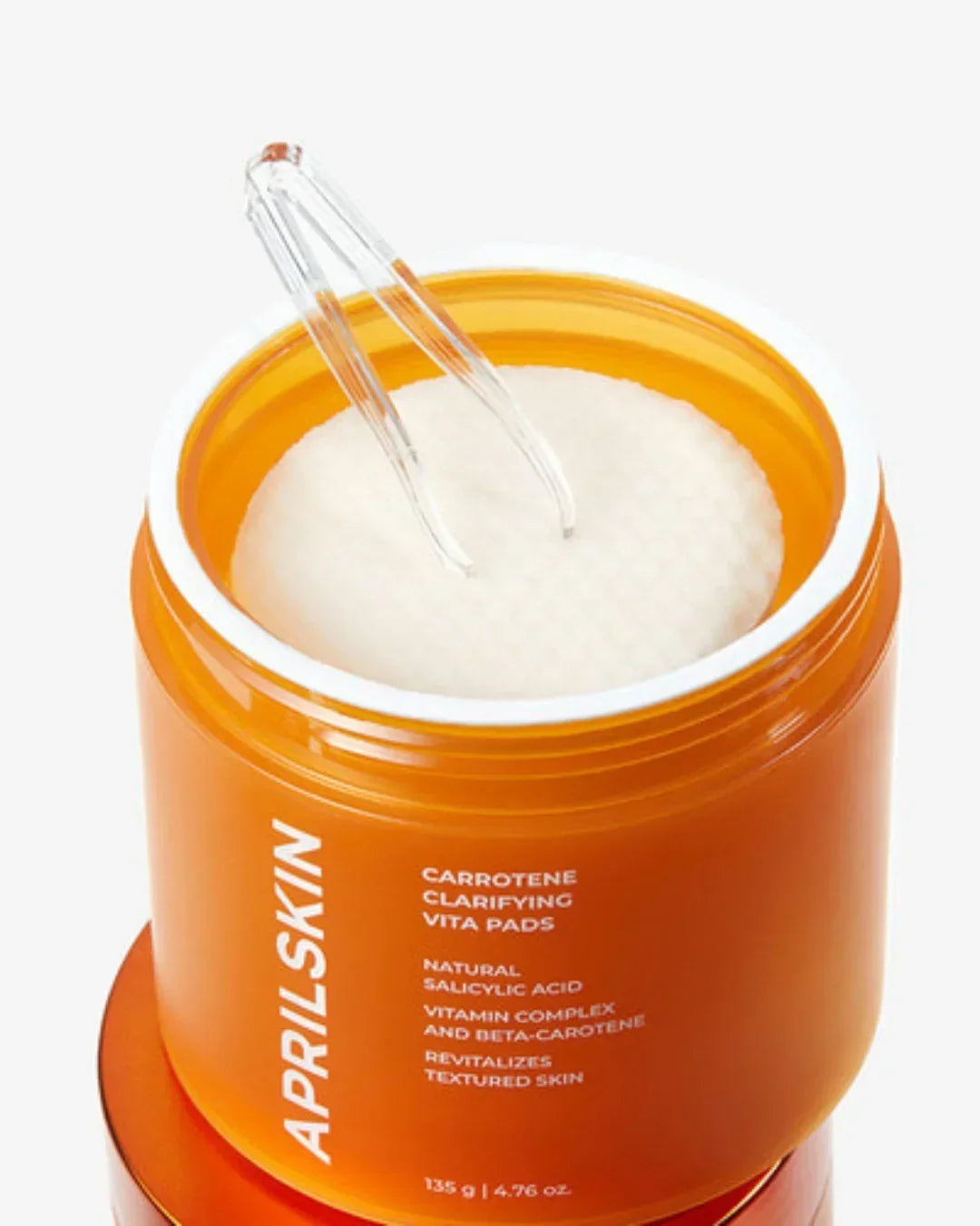 Opened orange jar of Aprilskin Carotene Clarifying Vita Pads with cotton pads and clear tweezer