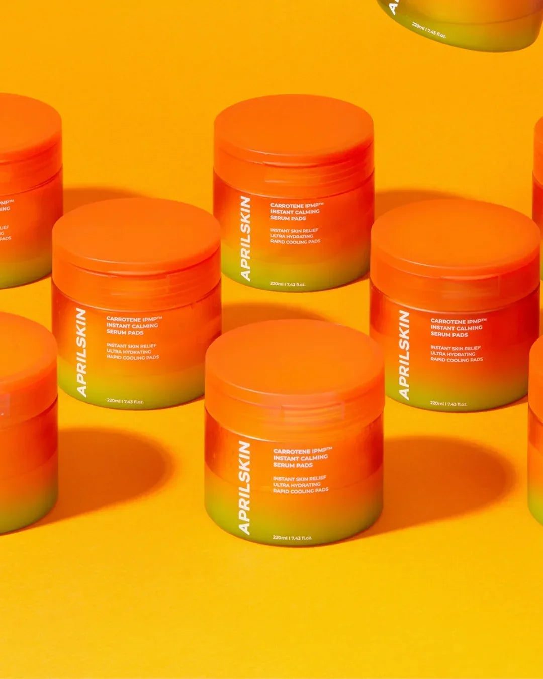 Multiple Aprilskin Carrotene IPMP Instant Calming Serum Pads containers on vibrant yellow background
