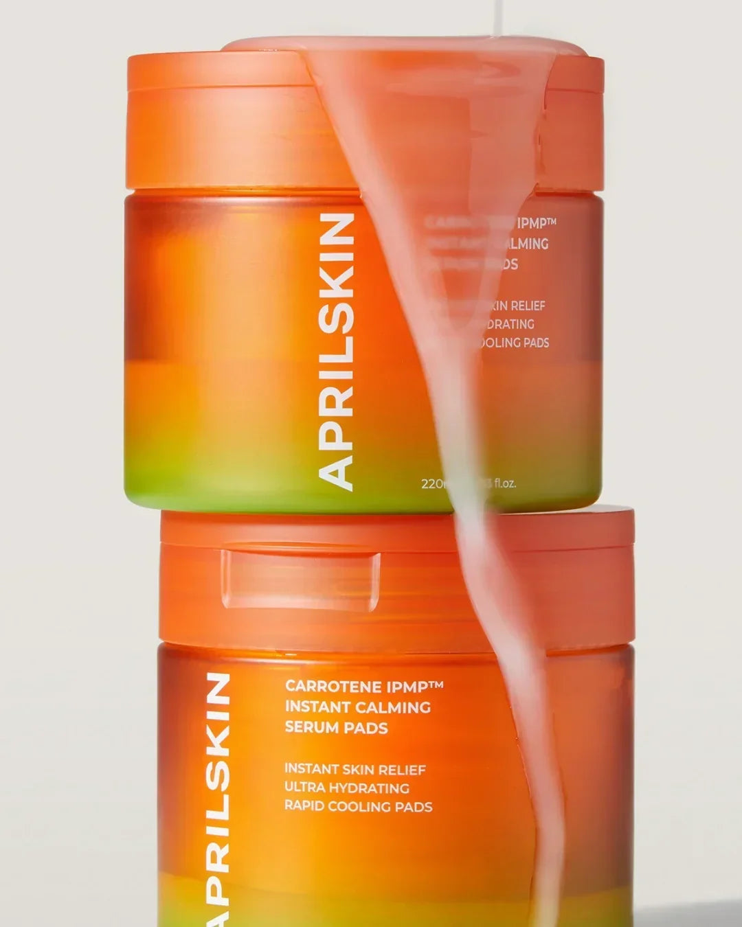 Two stacked Aprilskin Carrotene IPMP instant calming serum pads containers with orange and green gradient