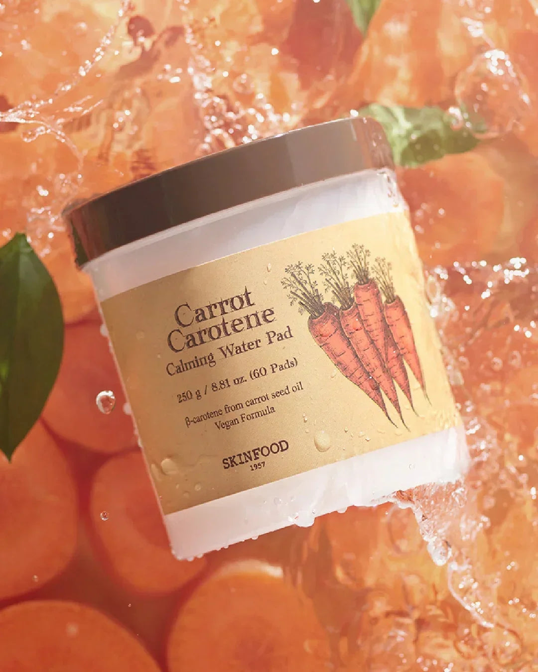 Skinfood Carrot Carotene Calming Water Pad container with carrot slices and water splash background