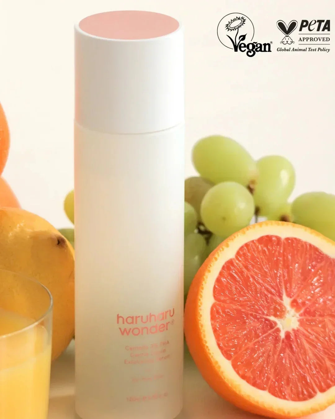 HaruHaru Wonder Centella 3% PHA gentle liquid exfoliating serum bottle surrounded by grapefruit, grapes, and a glass of juice