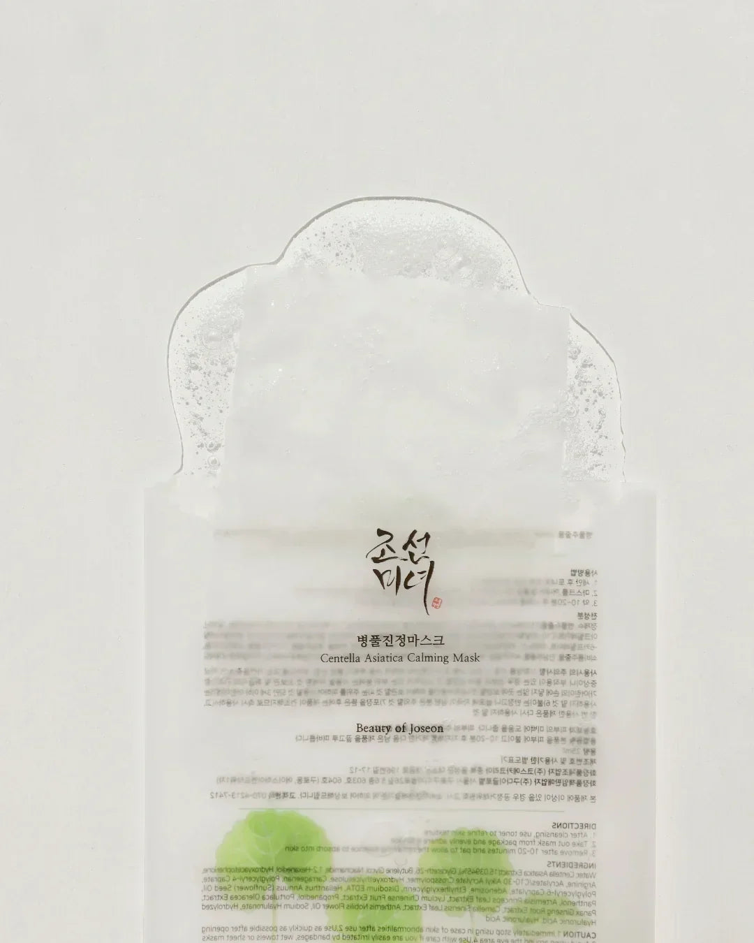 Centella Asiatica Calming Mask sheet with moist texture and bubbles on white background
