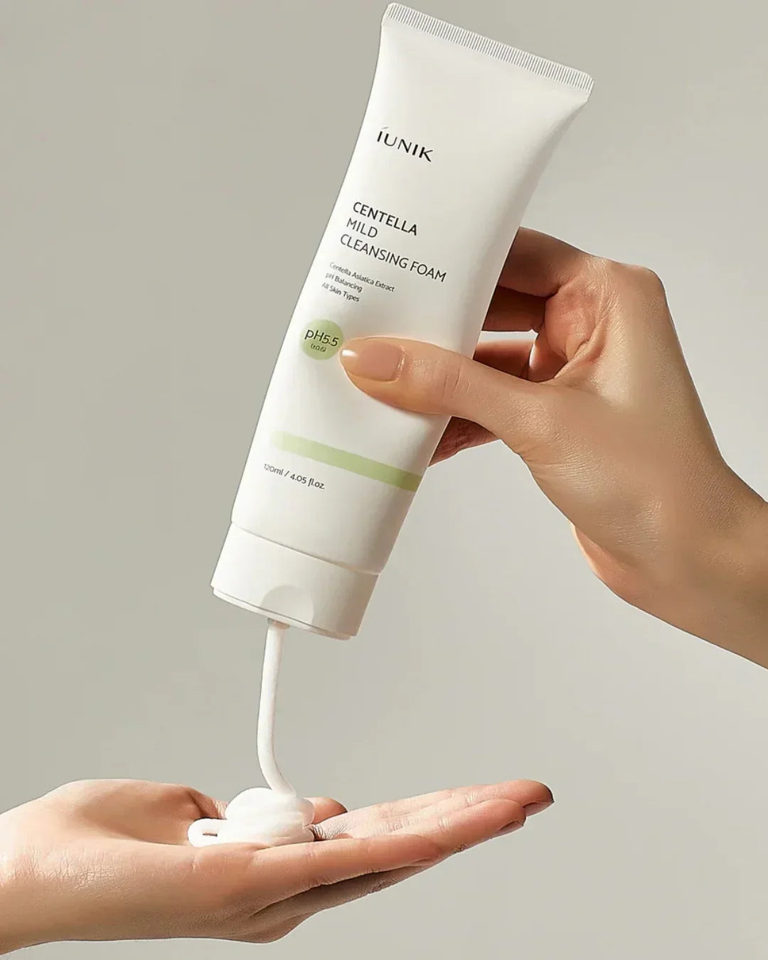 Hand dispensing iUNIK Centella Mild Cleansing Foam with pH 5.5 onto palm, skincare product for all skin types
