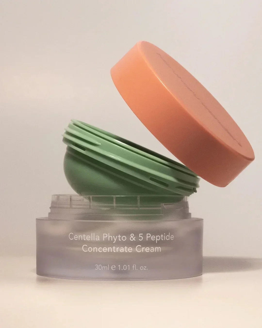 Open Centella Phyto & 5 Peptide Concentrate Cream in frosted jar with peach lid on white background