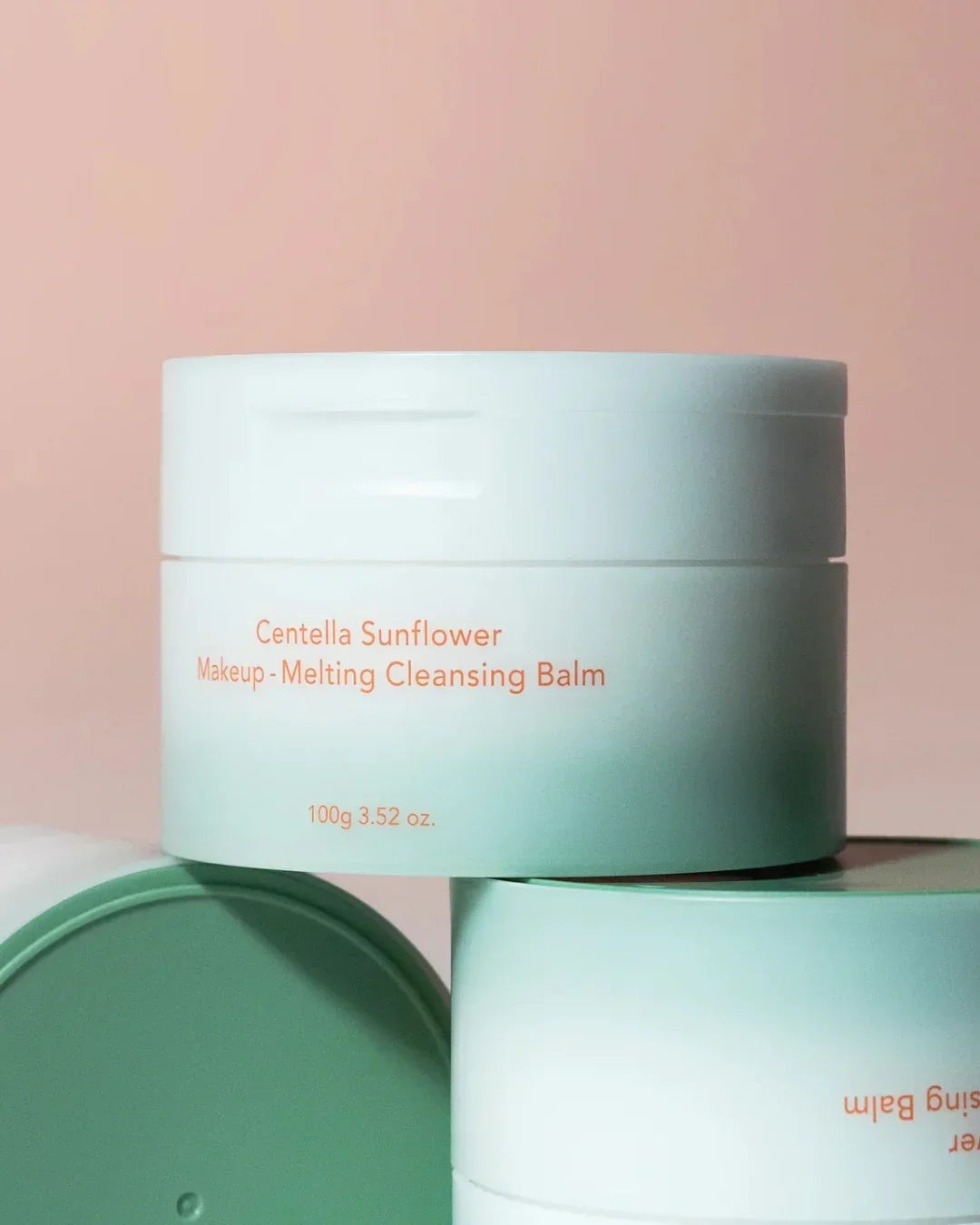 Centella Sunflower Makeup Melting Cleansing Balm jar on pastel pink background, skincare product