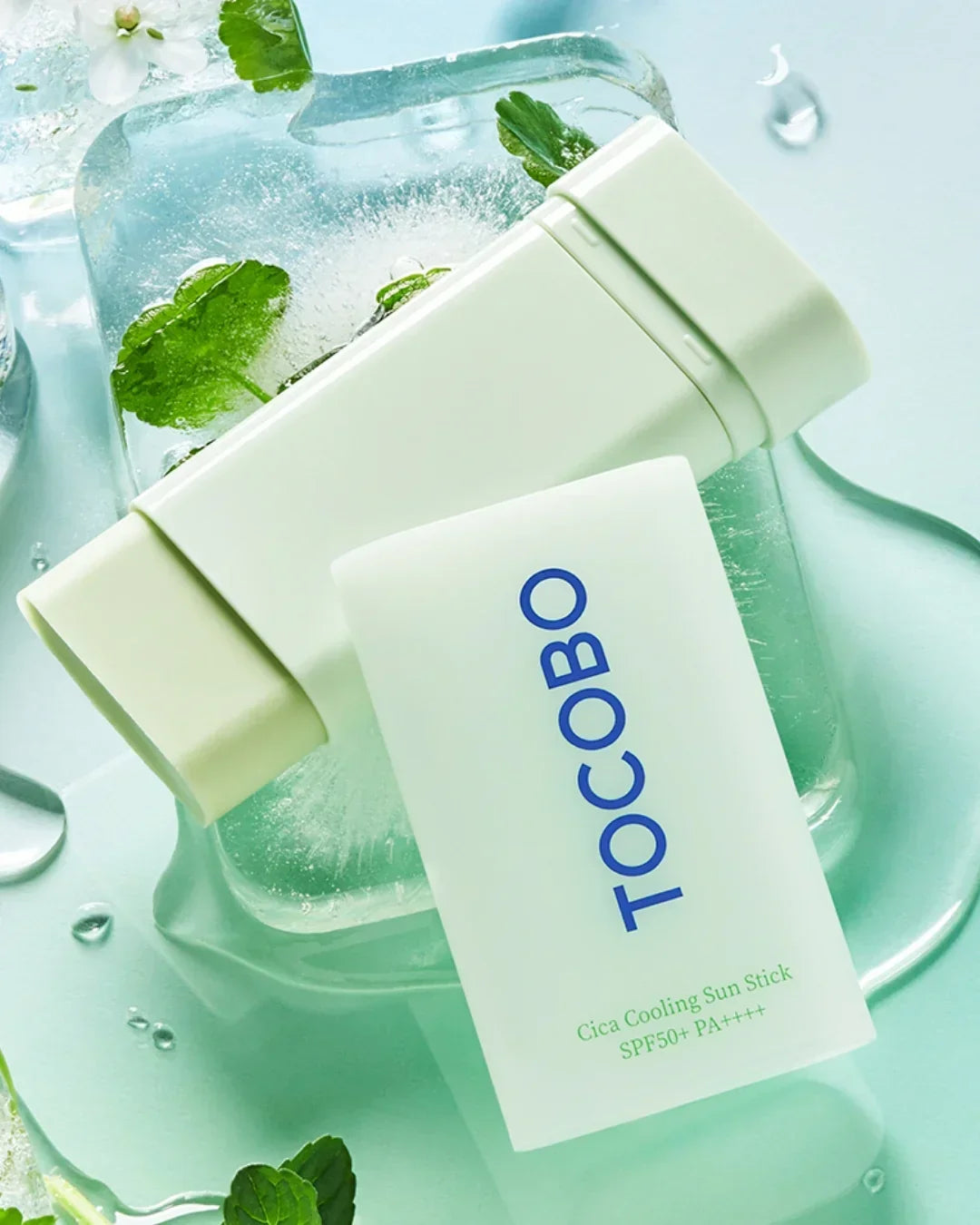 TOCOBO Cica Cooling Sun Stick SPF50+ PA++++ on ice with green leaves and water droplets