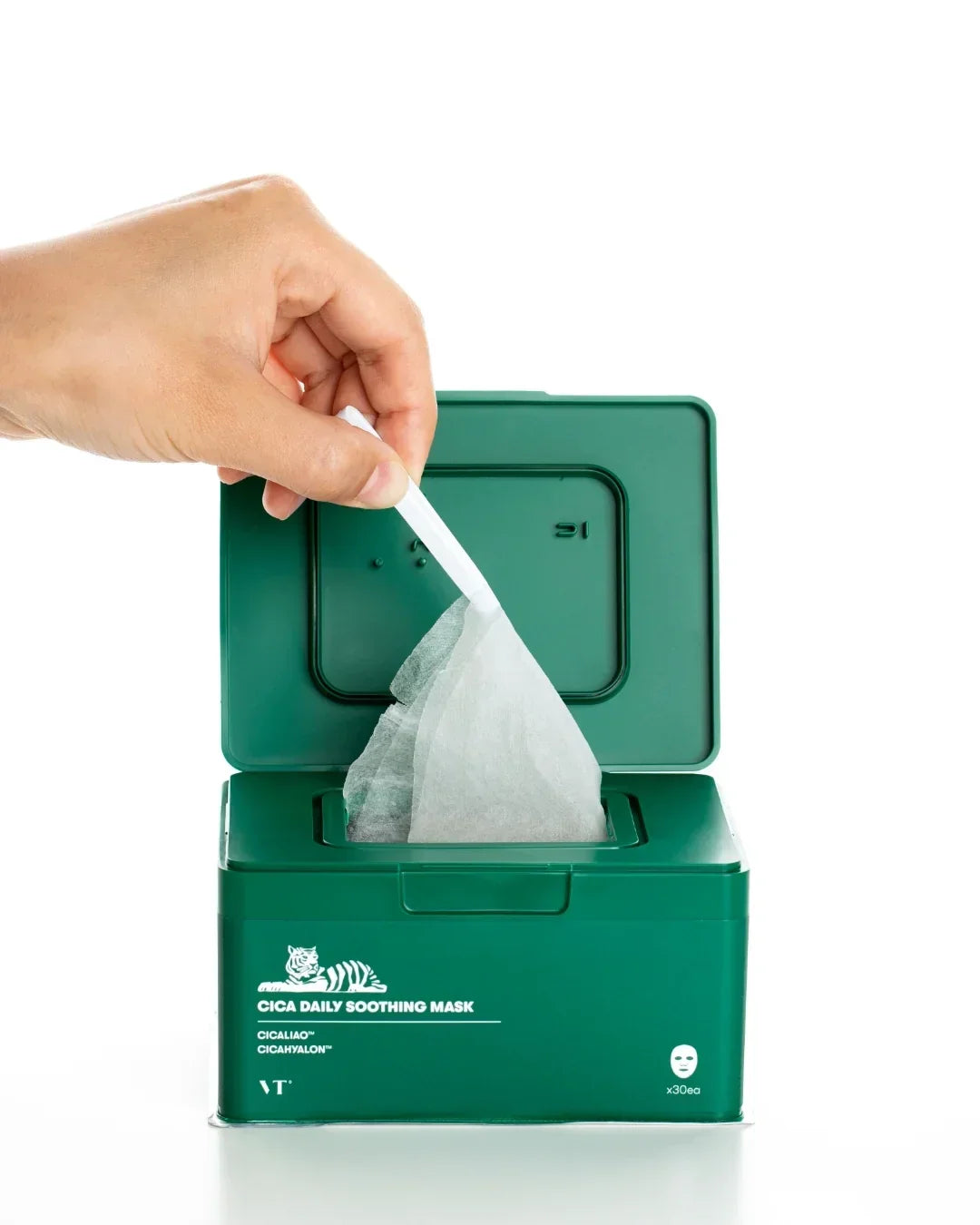 Hand pulling a sheet mask from a green container labeled Cica Daily Soothing Mask with 30 pieces