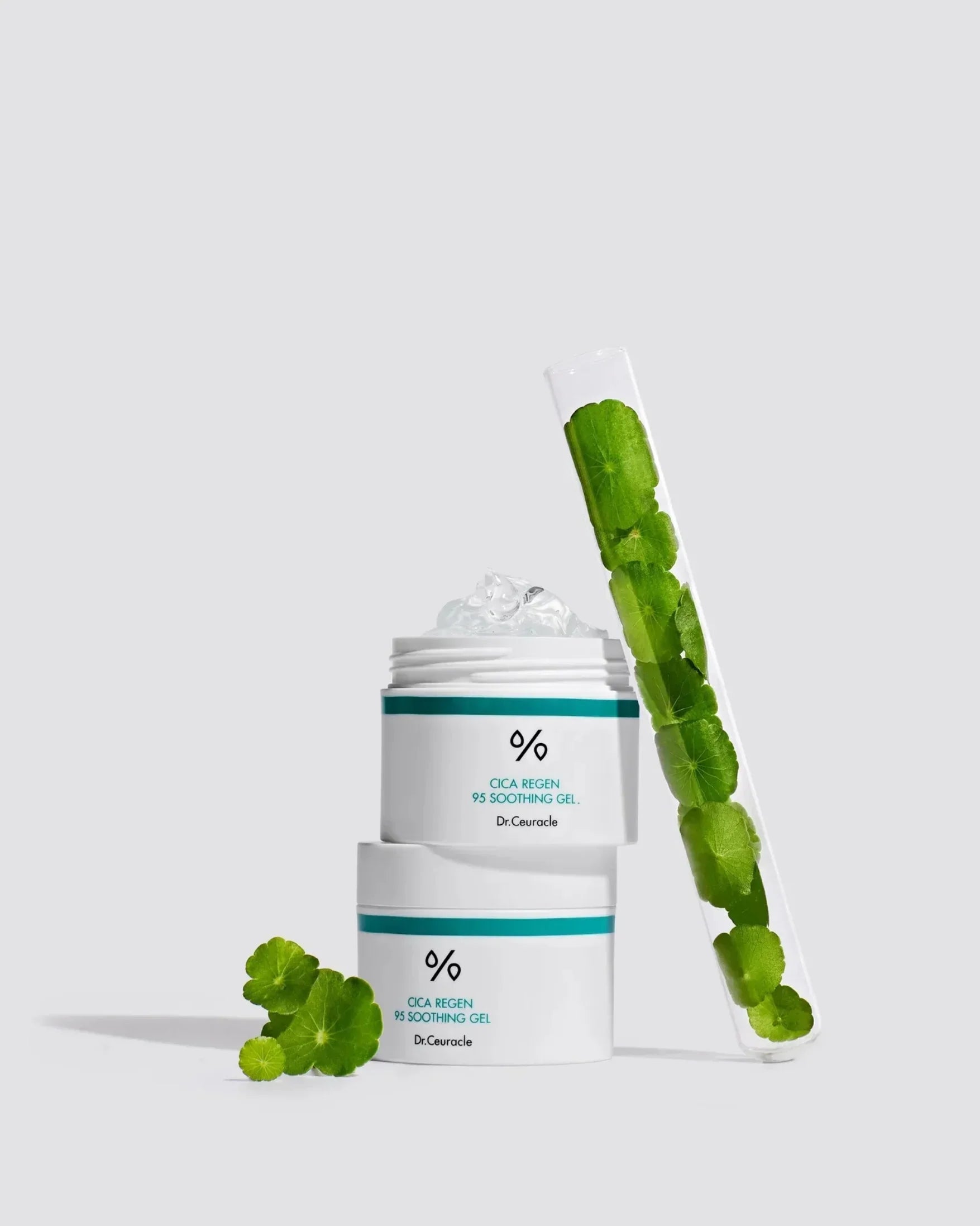 Dr.Ceuracle Cica Regen 95 Soothing Gel jars with clear gel and green centella leaves in test tube on light background
