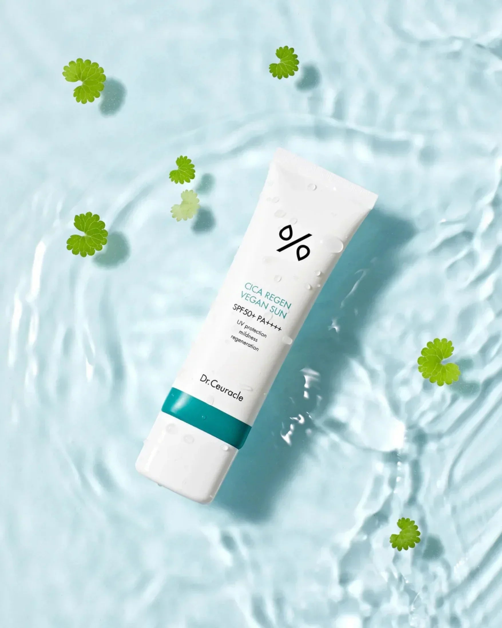Dr.Ceuracle Cica Regen Vegan Sun SPF50+ PA++++ sunscreen tube floating in water with green leaves