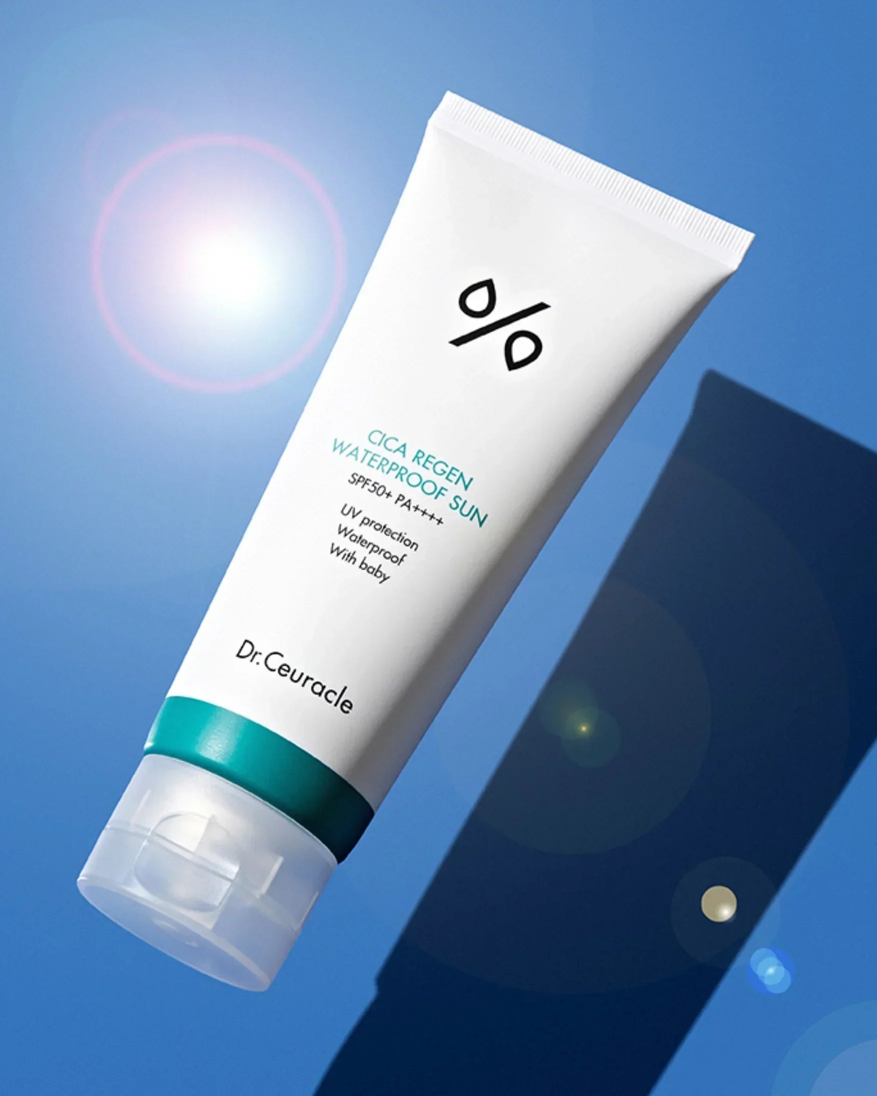 Dr. Ceuracle Cica Regen Waterproof Sun SPF50+ PA++++ sunscreen tube with lens flare on blue background