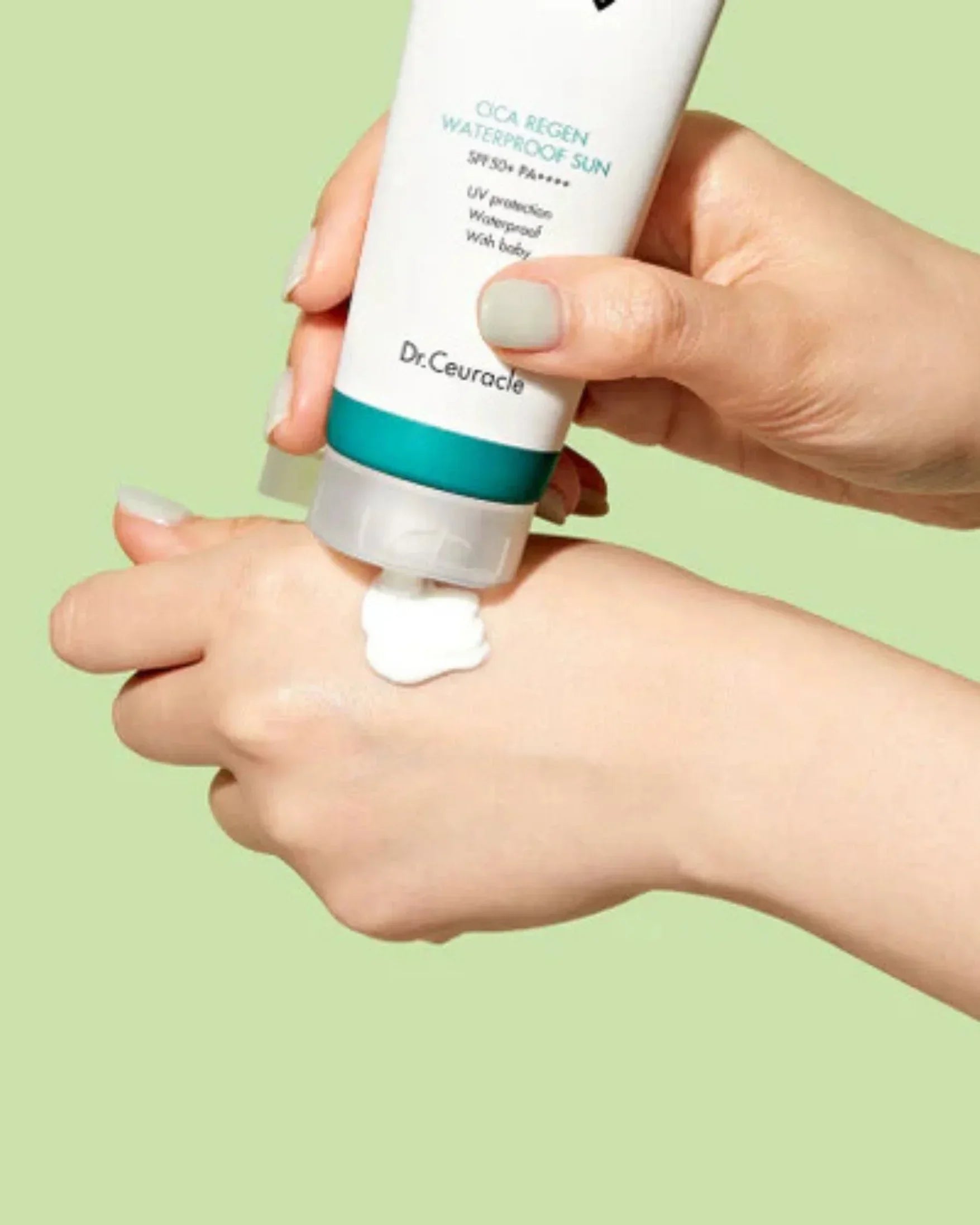 Tube of Dr. Ceuracle Cica Regen Waterproof Sun SPF 50+ sunscreen cream on hand with light green background